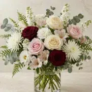 Bouquet de fleurs élégant avec roses blanches roses pâles et bordeaux dans un vase en verre